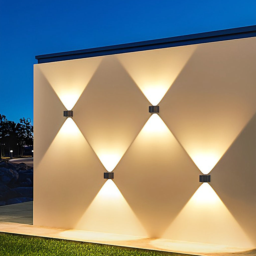 Outdoor wall sconce up and down lighting creating a geometric light pattern on a beige wall.