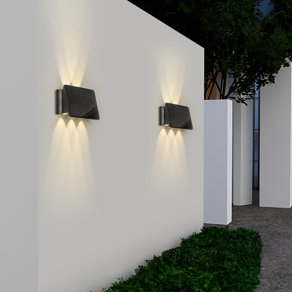 Outdoor wall sconce up and down lighting mounted on a white wall beside a green lawn.