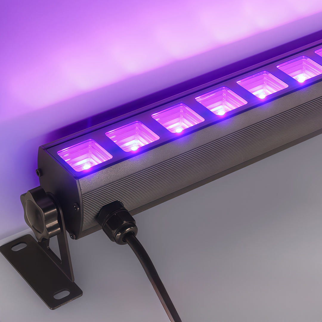 Outdoor wall wash lighting close-up showing purple LED modules inside aluminum fixture housing.