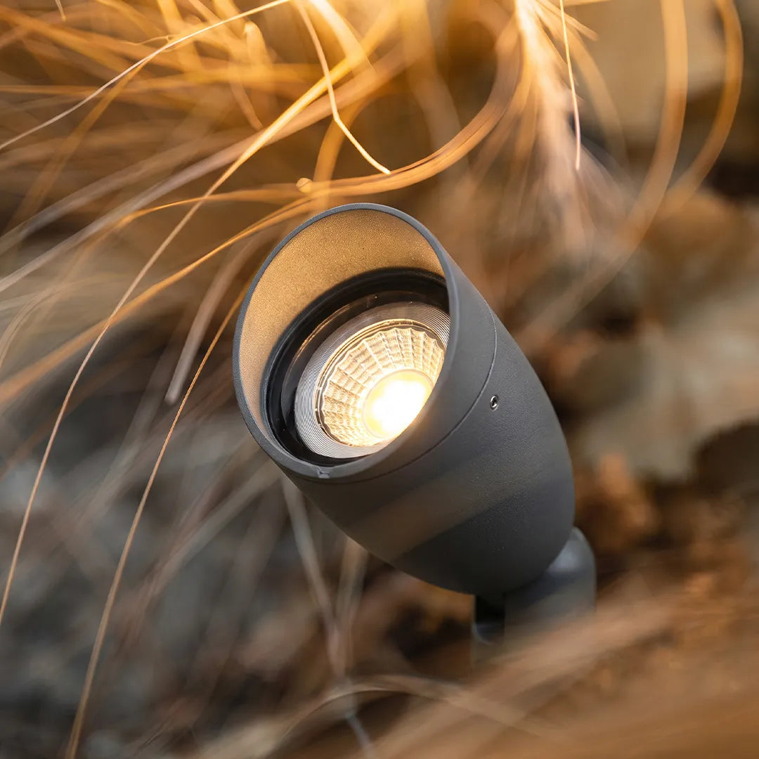 Outdoor waterproof LED landscape spotlight close-up with a black adjustable head and warm beam.