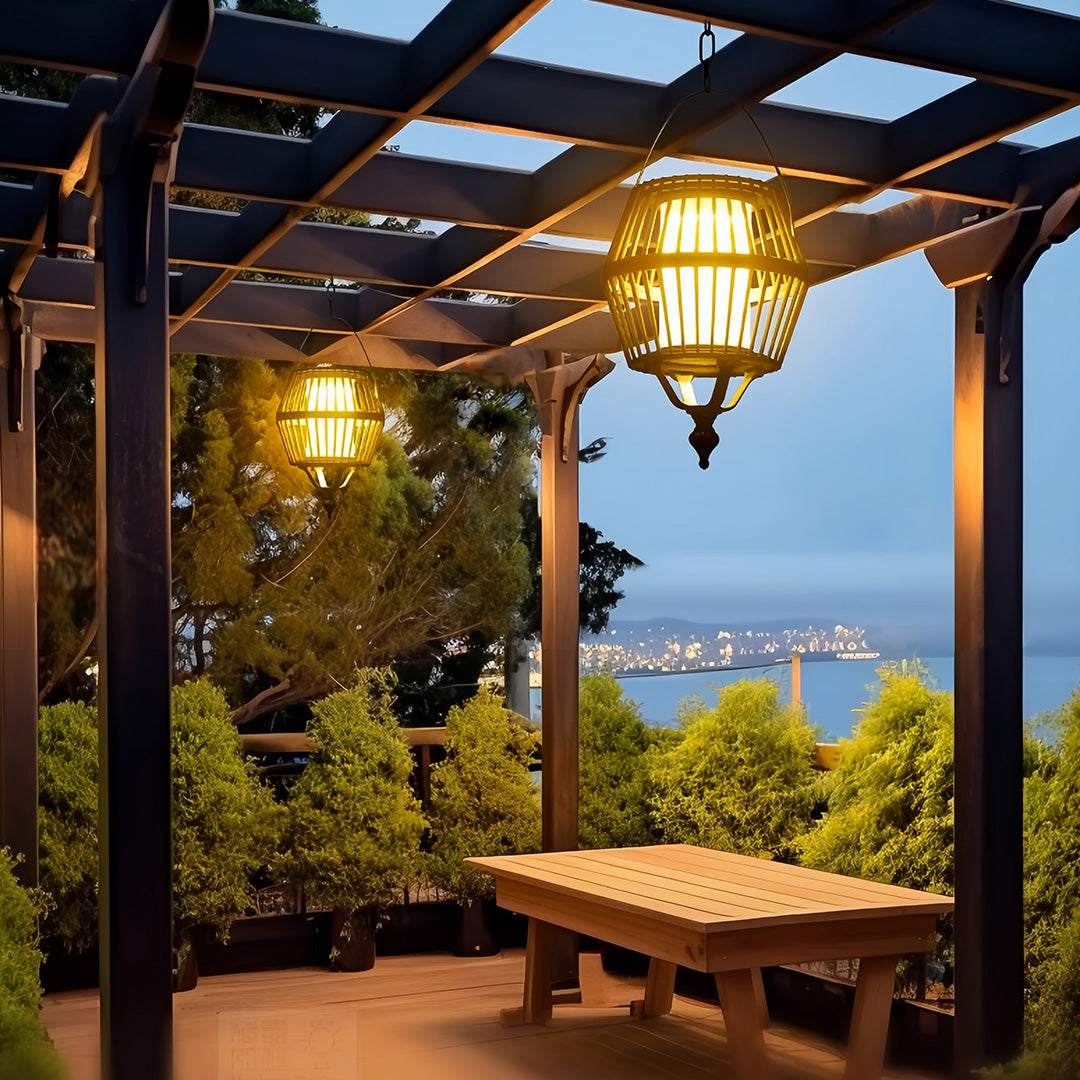 Outdoor seating area featuring a woven japanese lantern pendant light suspended above a wooden bench with a harbor view.