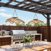 Outdoor woven pendant light hanging above an outdoor kitchen with a sculptural rattan shade.