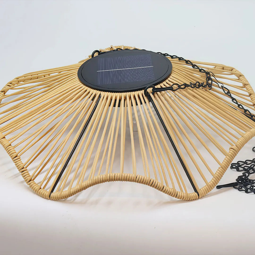 Outdoor woven pendant light close-up showing the solar panel, woven shade, and hanging chain.