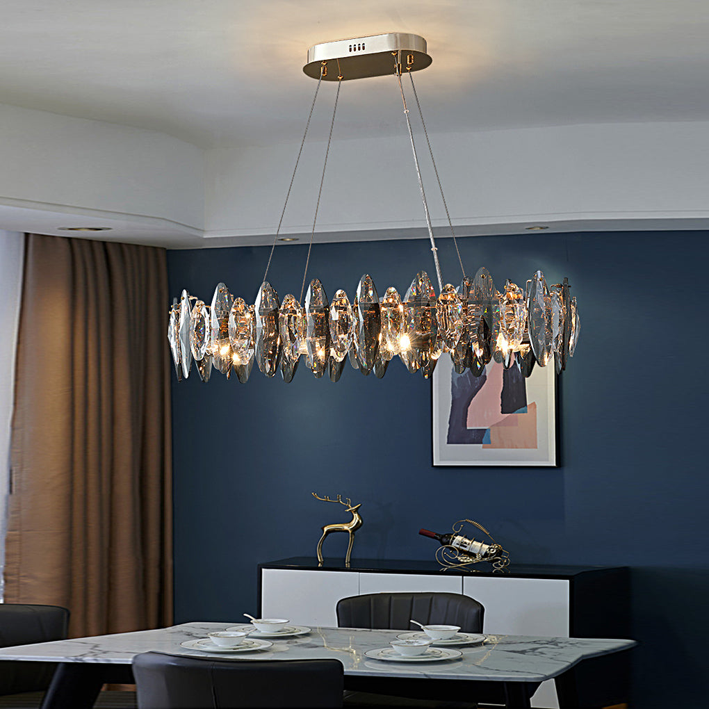 Oval chandelier with crystals over a dining table in a contemporary home with blue accents.