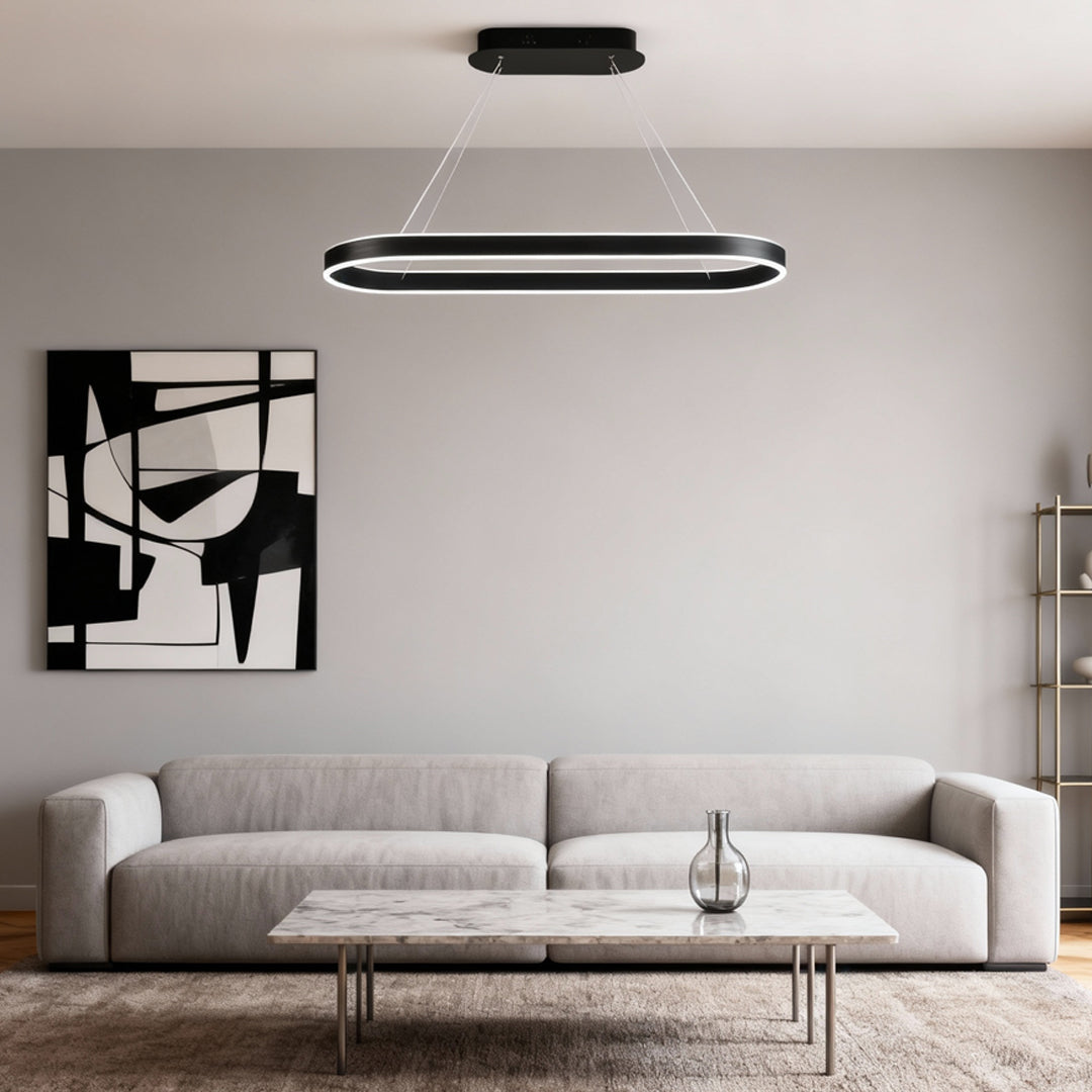 Black oval LED pendant light centered above a contemporary sofa in a neutral living space.
