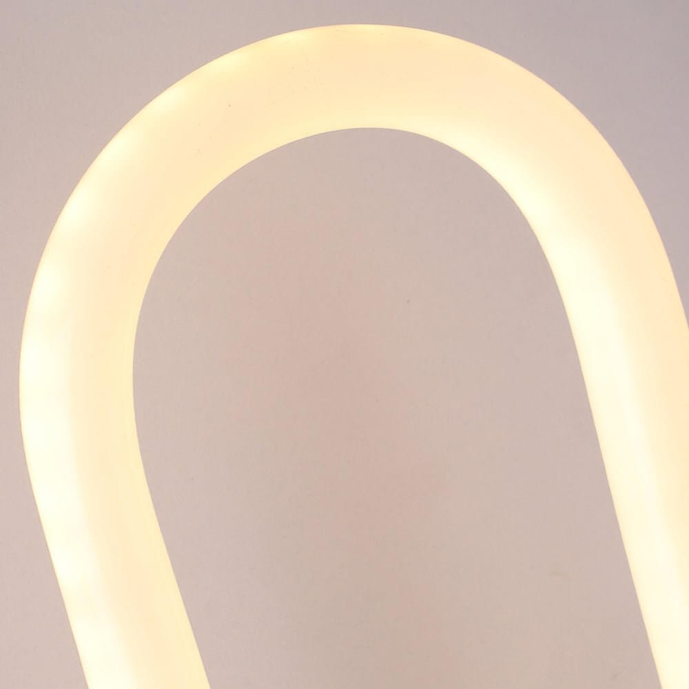 A close-up of a stylish oval LED wall sconce with a sleek black finish, casting a warm and inviting glow.