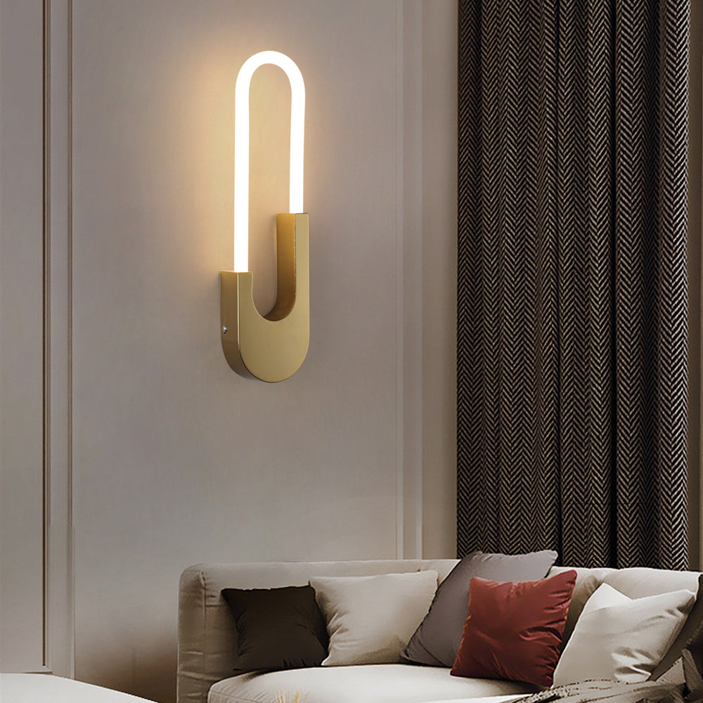 Sleek black and gold oval LED wall sconce mounted next to the bed, creating a calming and modern atmosphere.