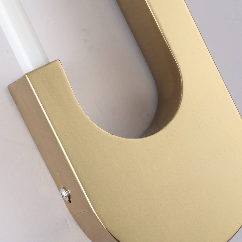 Gold and black oval LED wall sconce above a bed, offering contemporary lighting with an elegant design.