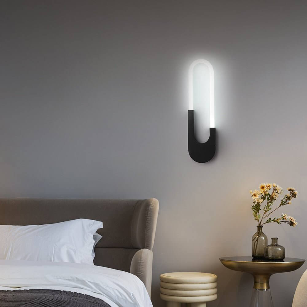 Minimalist oval LED wall sconce with a sleek design, perfect for modern bedroom or hallway lighting.