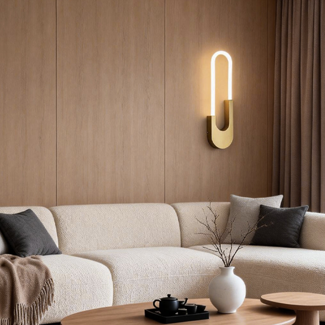 Elegant oval LED wall sconce in a minimalist design, mounted on the wall in a stylish bedroom for soft, warm lighting.