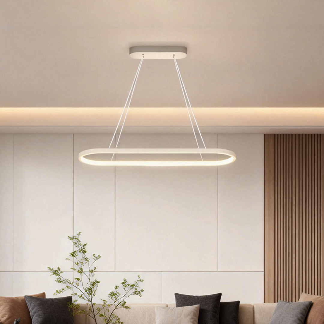 Oval linear pendant light installed in modern interior with soft ambient glow.