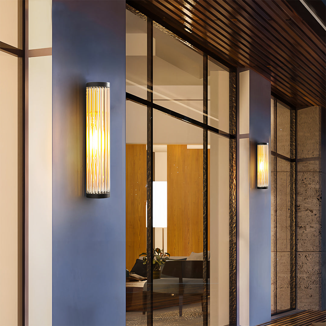 Pair of amber glow outdoor wall LED light fixtures framing large glass doors, enhancing the warmth of the home exterior.