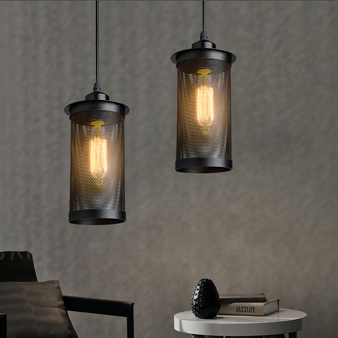 Pair of black mesh retro industrial pendant lights showcasing the glowing filament of vintage Edison bulbs indoors.