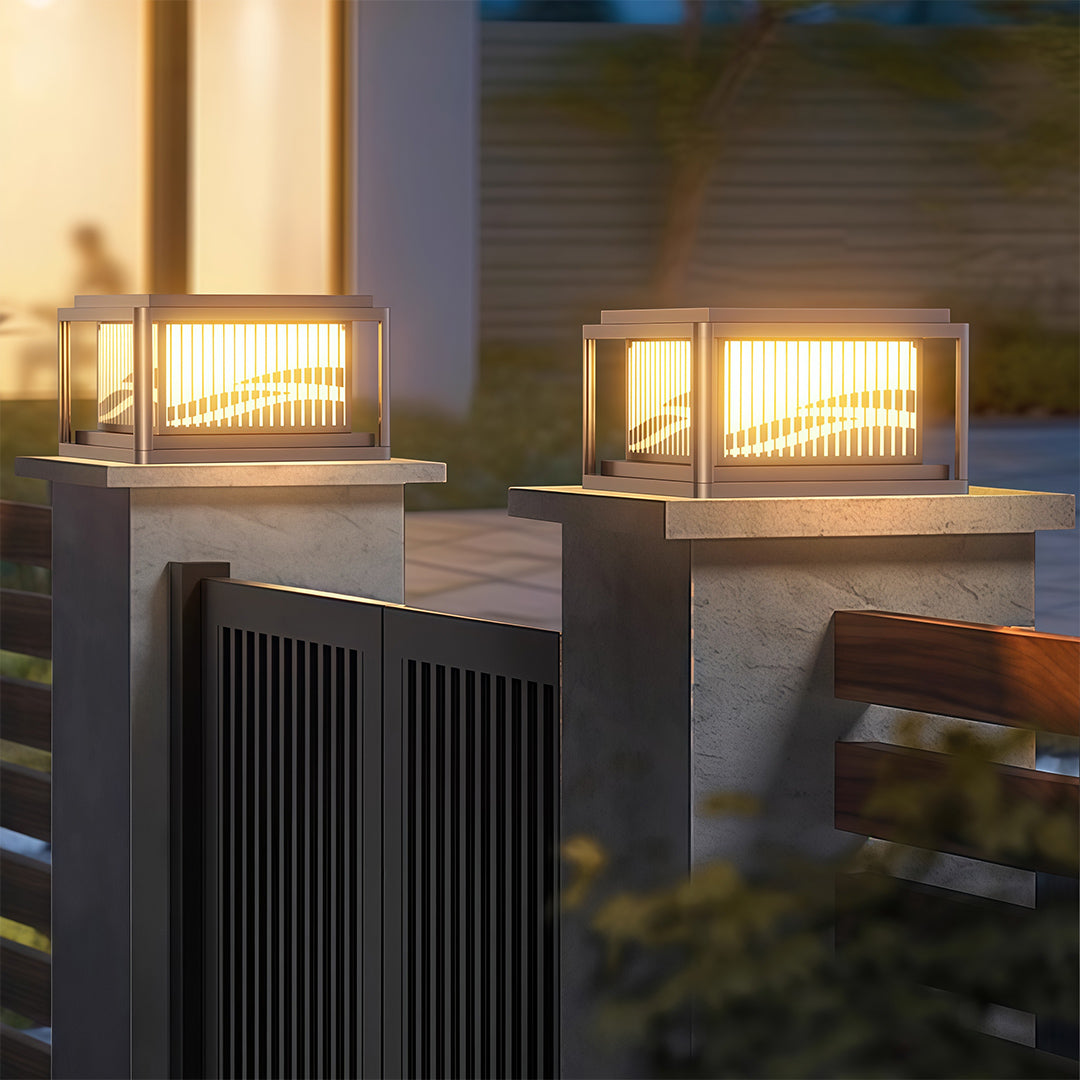 Pair of contemporary pillar lights flanking modern concrete columns with grey architectural elements at twilight.