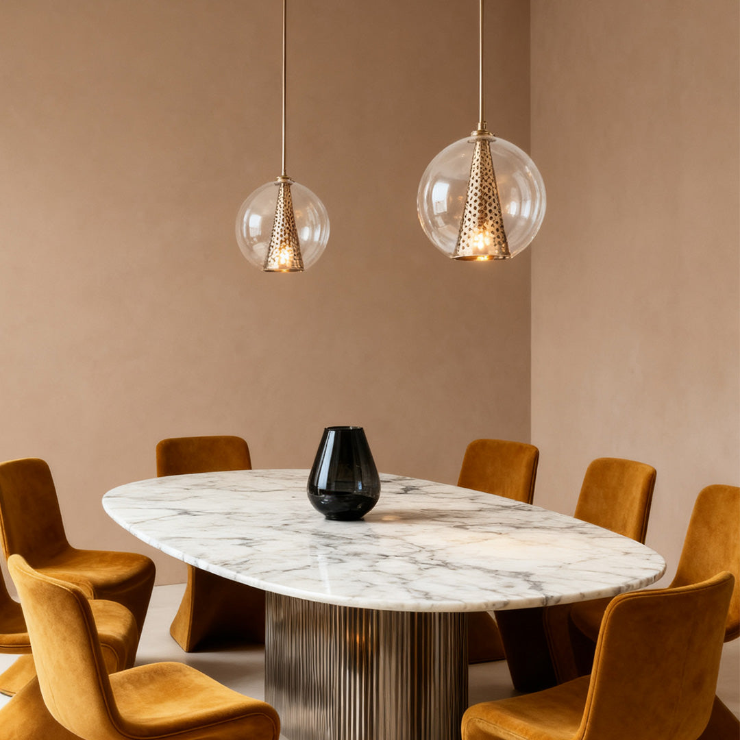 Pair of glass ball pendant lights adding a soft, decorative touch to a dining area with velvet yellow chairs and a light taupe background.