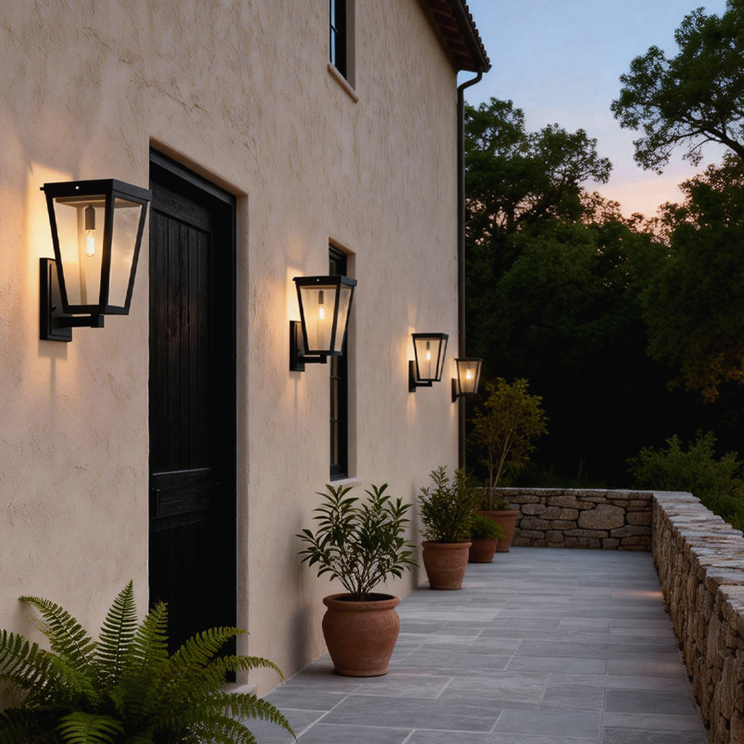 Pair of exterior LED wall lanterns with sleek design lighting up a house facade and garden pathway at dusk.