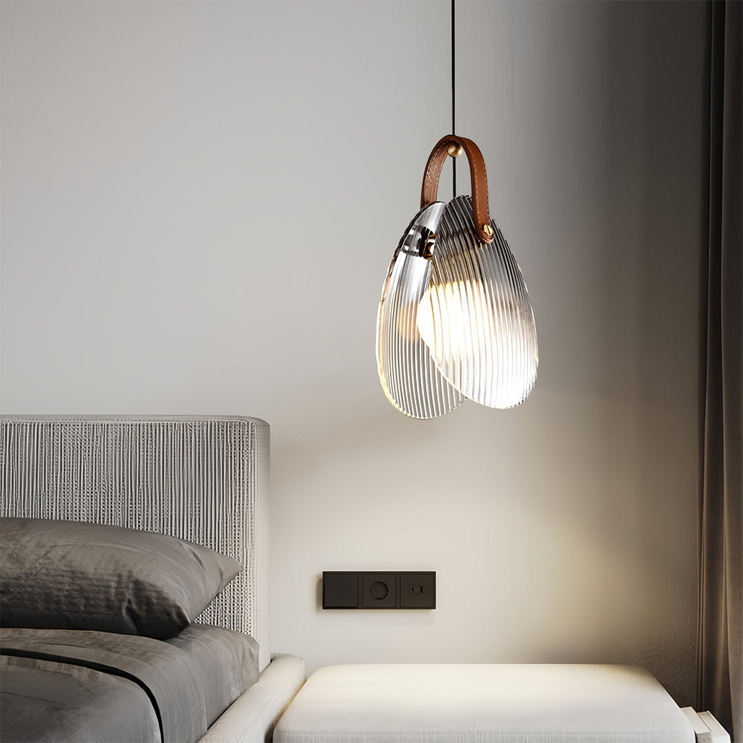Pair of hanging glass pendant lights creating ambient lighting in contemporary bedroom setting