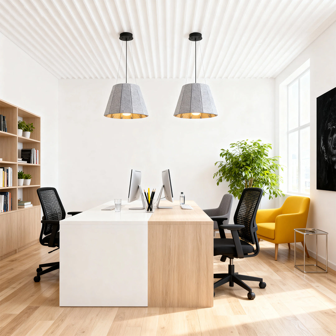 Pair of gray felt industrial pendant light fixtures illuminating a large, modern collaborative office desk area. 