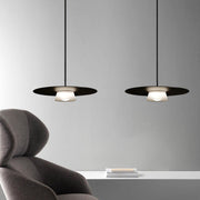 Pair of island pendant light fixtures positioned over contemporary seating area with gray chairs