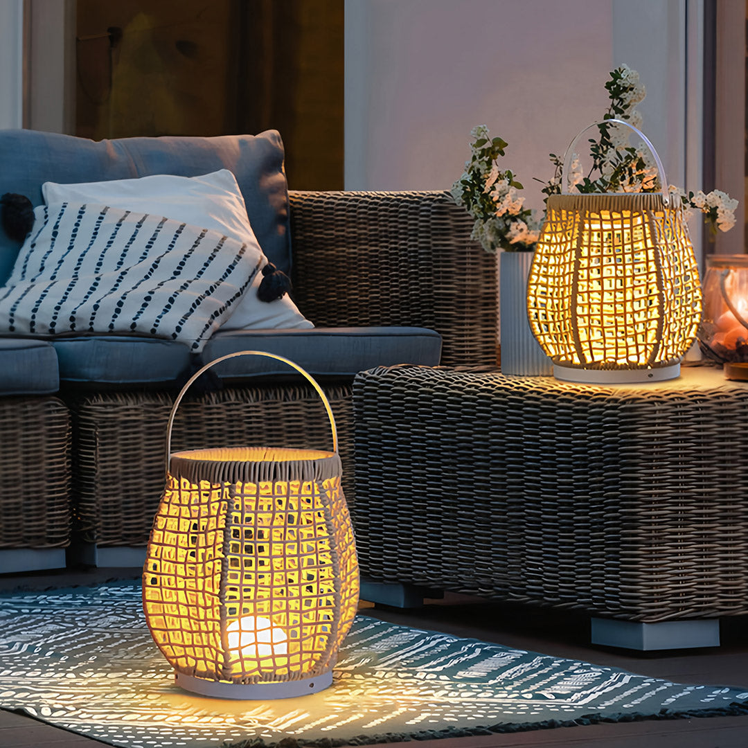 Pair of woven outdoor lanterns accenting an outdoor seating area with woven furniture and soft lighting for evening relaxation.