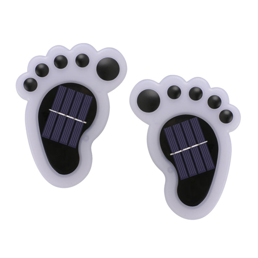 Pair of white solar-powered footprint lights with black solar panels for garden pathway use