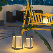 Pair of square camping lantern lights with carrying handles, illuminating a patio seating area with a yellow swing set in the background.