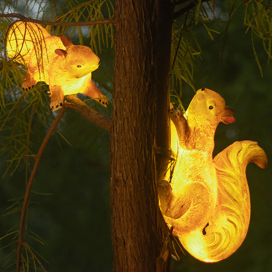 Pair of illuminated squirrel solar lights creating magical lighting effect in garden setting