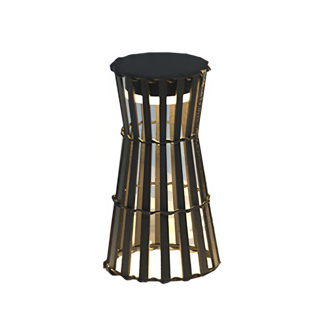 Pair of tall cylindrical outdoor black lanterns with vertical slats, casting a dramatic light and shadow pattern on a stone wall and wooden deck.