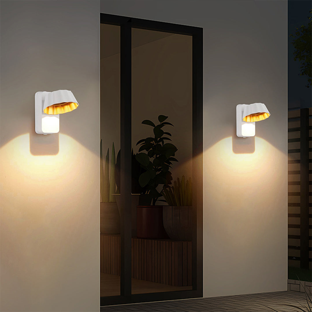 Pair of modern wall lights flanking mirror in stylish hallway with decorative plant