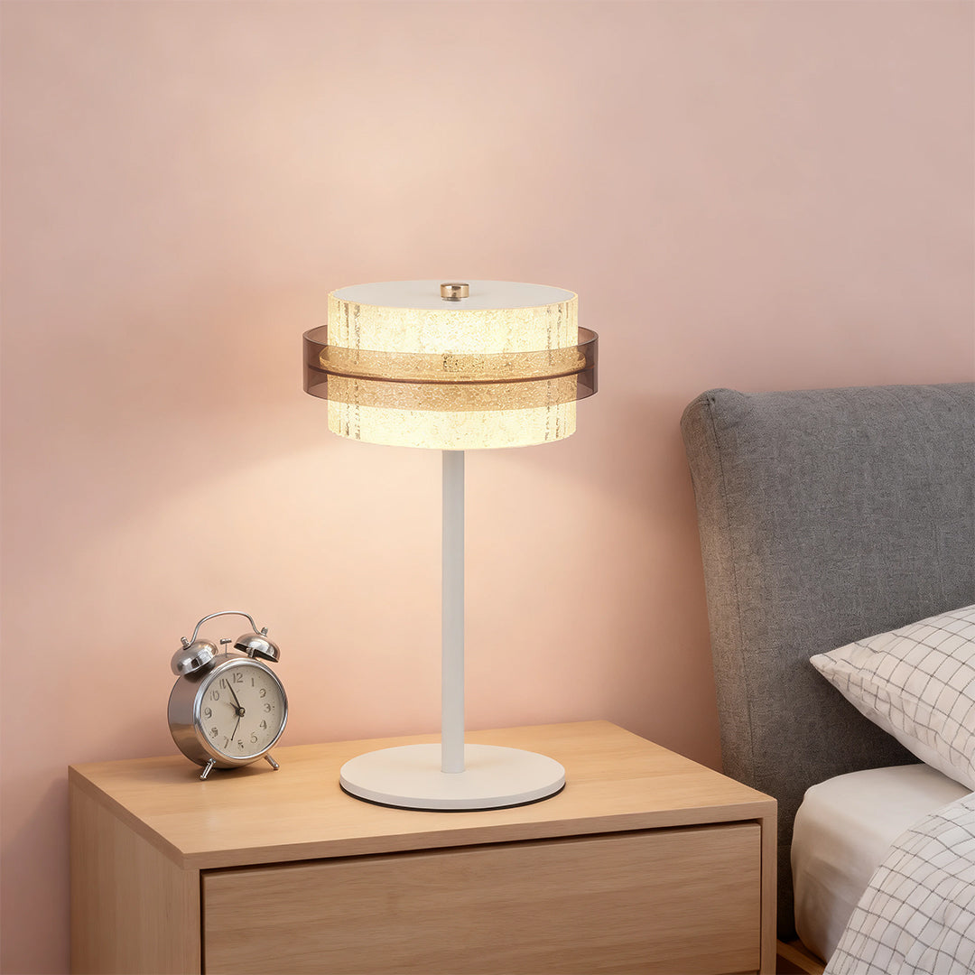Pair of white vintage metal table lamp styles and alarm clock on a minimalist white dresser in a soft pink room.