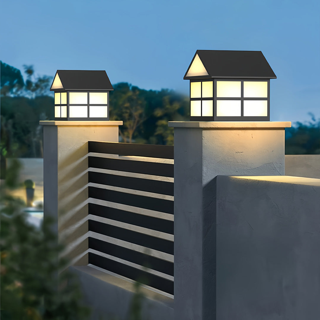 Paired gate pillar top lights mounted on modern walls, offering a symmetrical and welcoming exterior lighting effect.