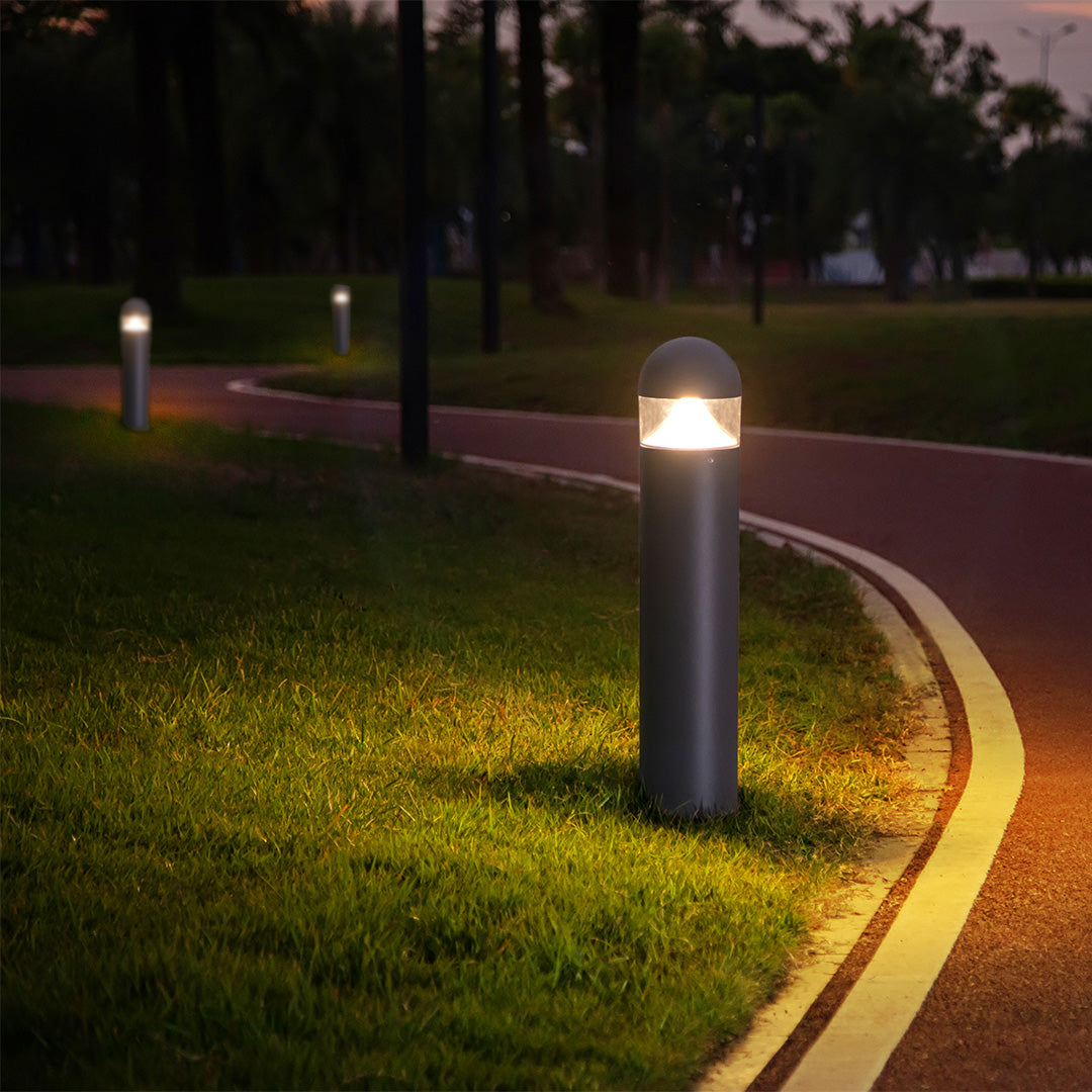 Contemporary bollard lights providing warm pathway illumination in park setting
