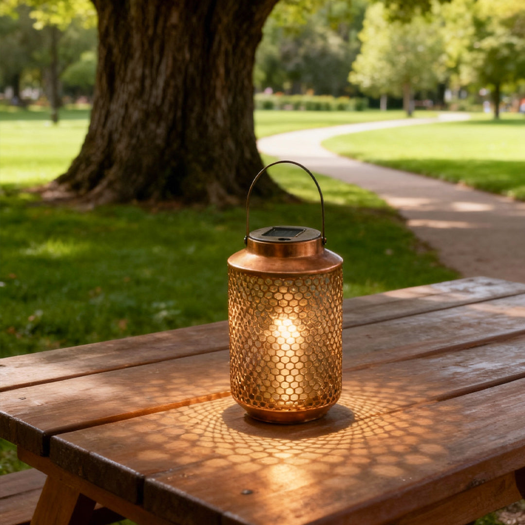 Portable solar lantern illuminating a picnic table in a park during golden hour.