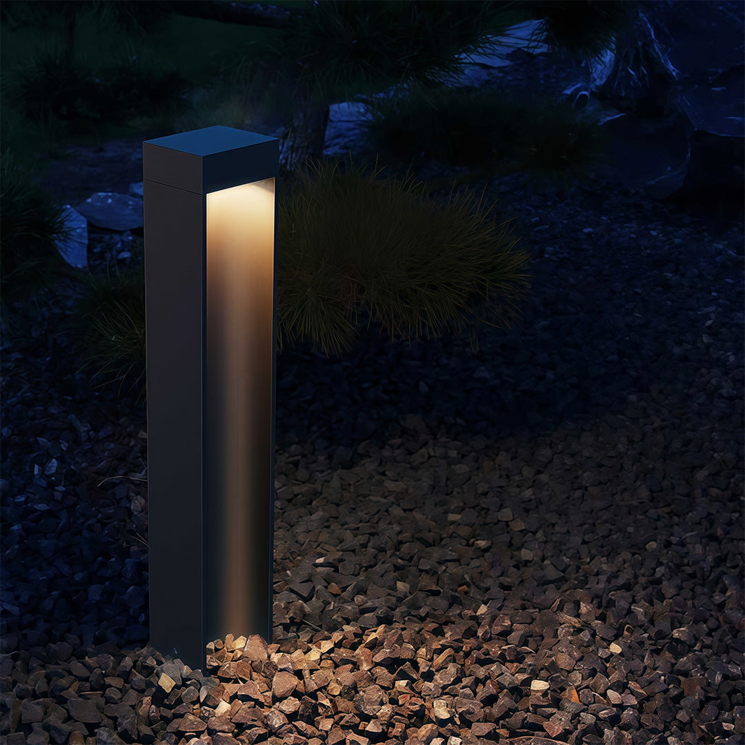 Path light stake placed near a paved walkway, enhancing the outdoor ambiance with subtle lighting.