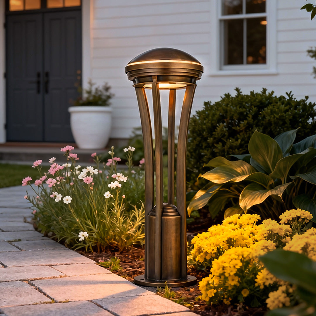 Path light stakes installed along a landscaped walkway, providing warm illumination among flowers and greenery.