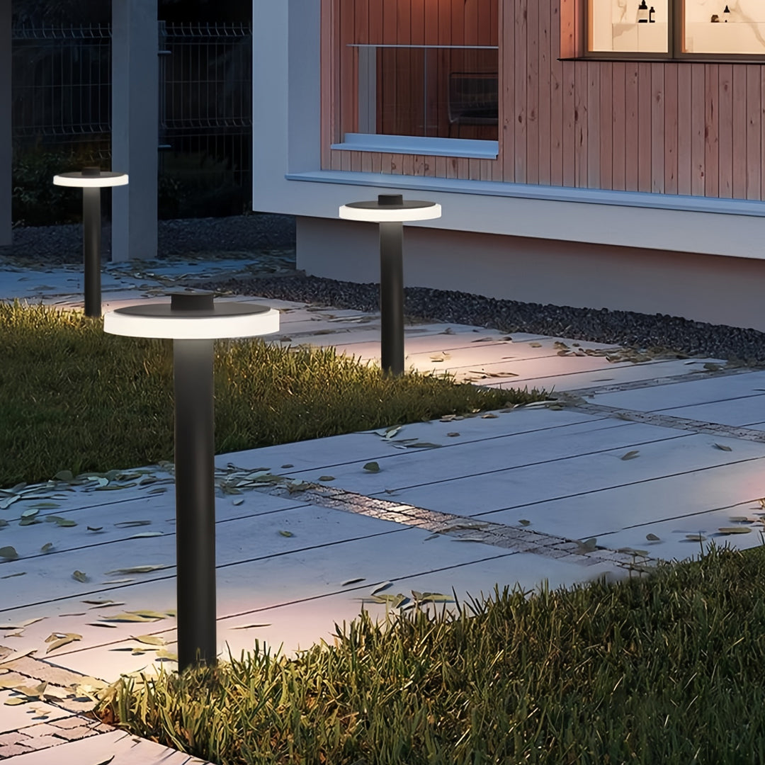 Modern dual-height path lighting outdoor fixtures providing ambient lighting along a stone pathway.