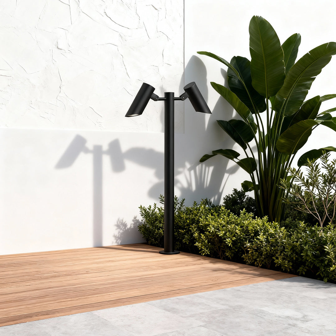 Contemporary exterior corner landscape highlighted by tall path lights led near greenery.