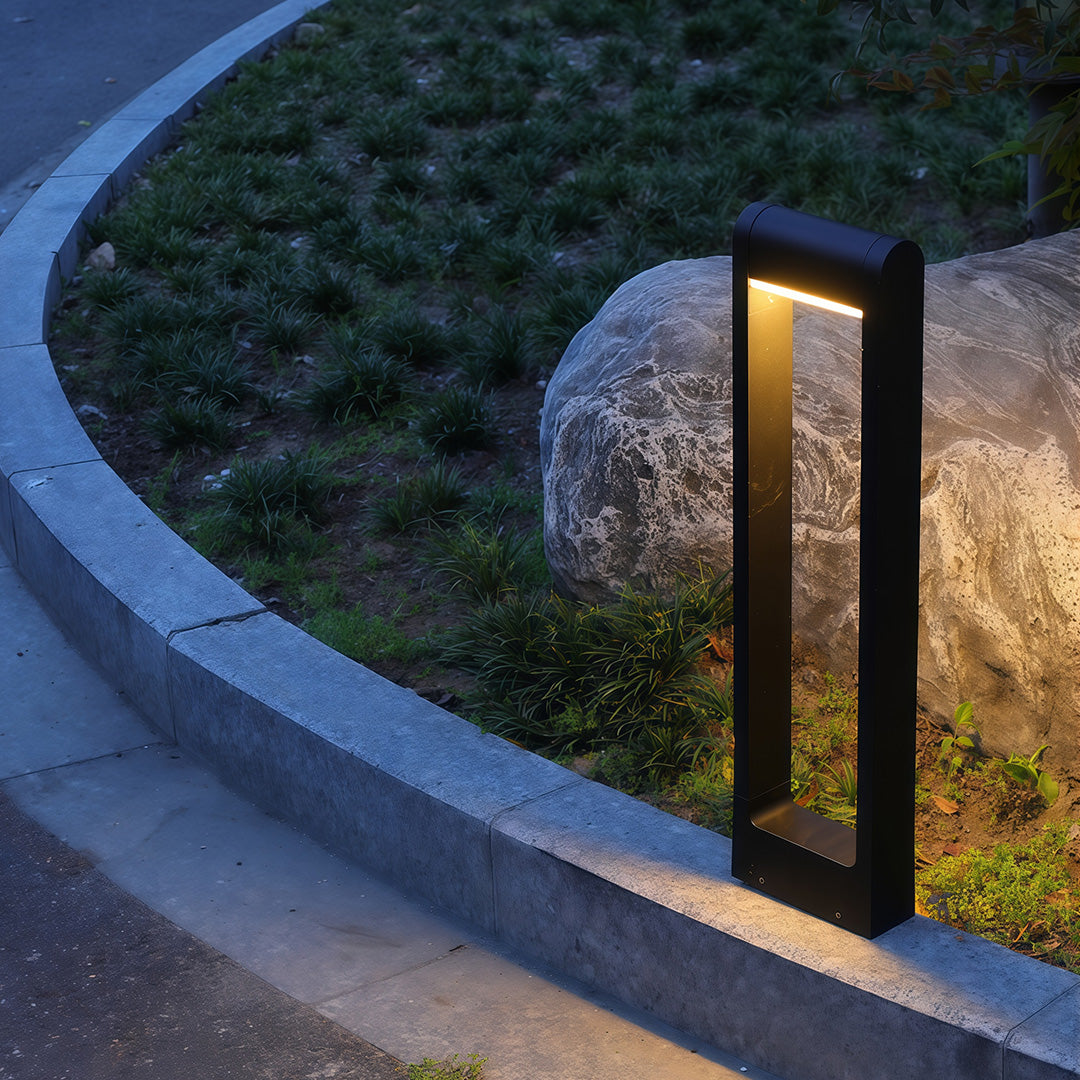 Pathway bollard light installed along a curved pathway, providing warm and inviting illumination.