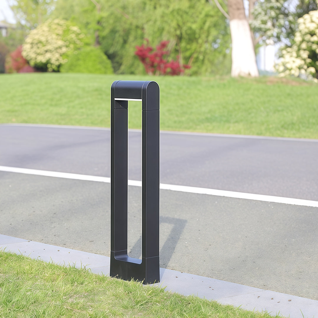 Pathway bollard light placed near a roadside, enhancing the outdoor ambiance with subtle lighting.