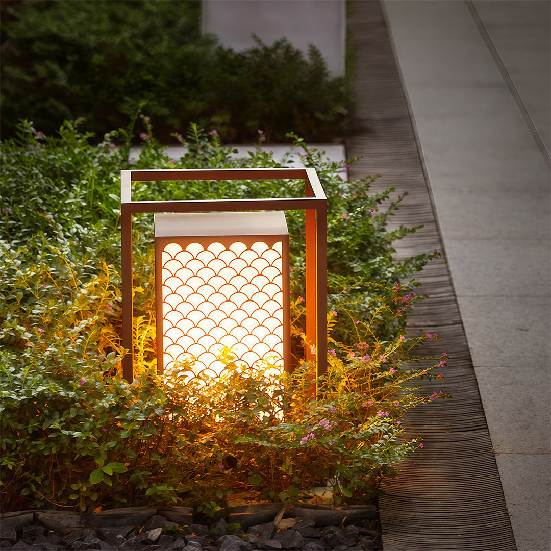 Decorative bollard light illuminating a pathway in a serene garden setting, adding warmth and style.