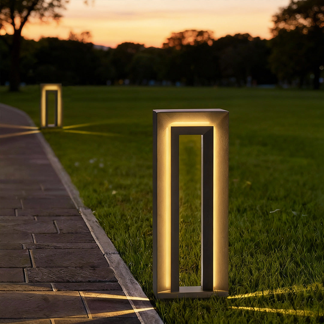 Outdoor pathway illuminated by lighted bollards LED posts creating a warm ambient glow at dusk.