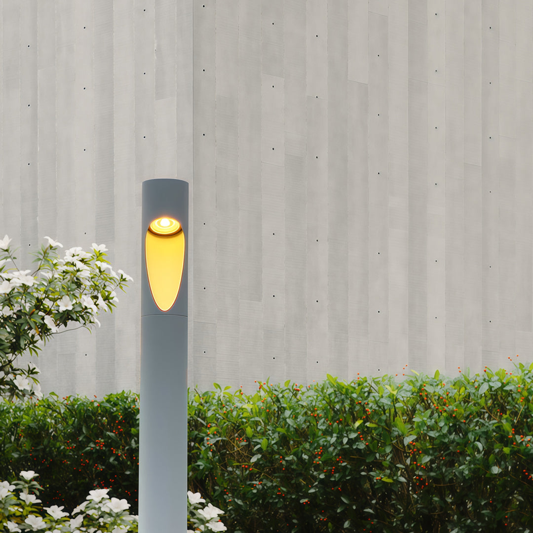 Garden pathway lined with installed garden bollard led lights creating soft warm illumination along wet stone pavement.