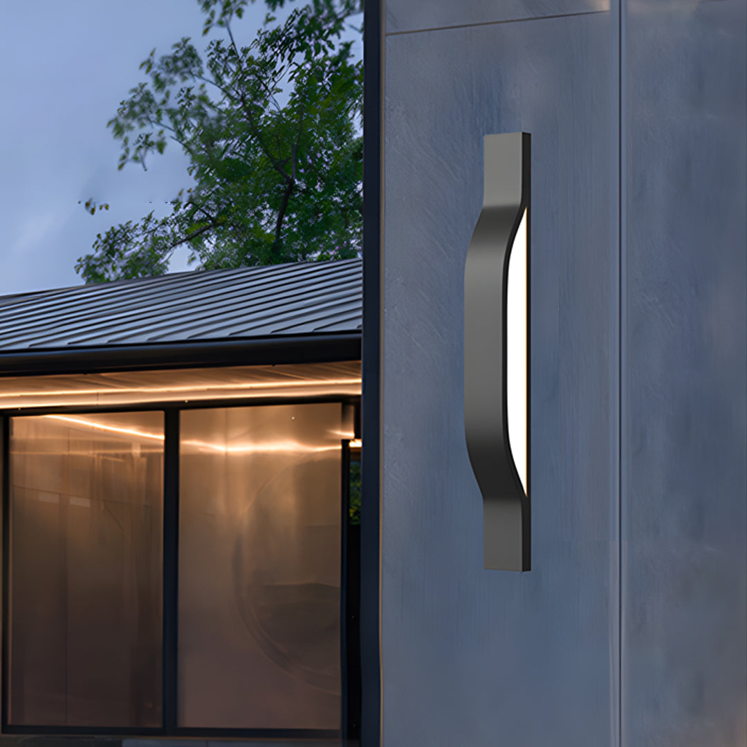 Modern outdoor exterior wall lights installed on a grey wall providing elegant evening pathway lighting.
