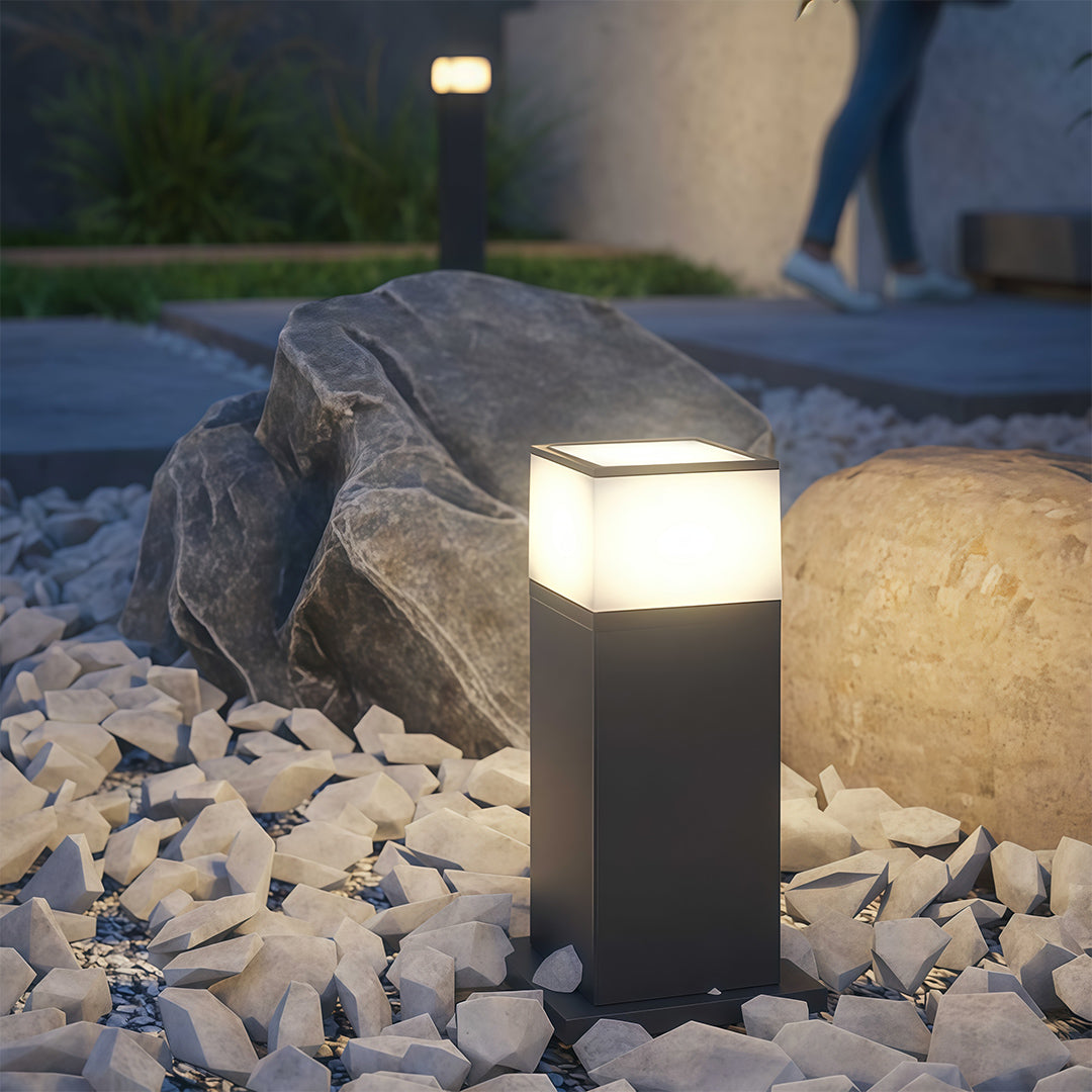 Pathway yard light in a garden with plants, adding a contemporary touch to the outdoor space.