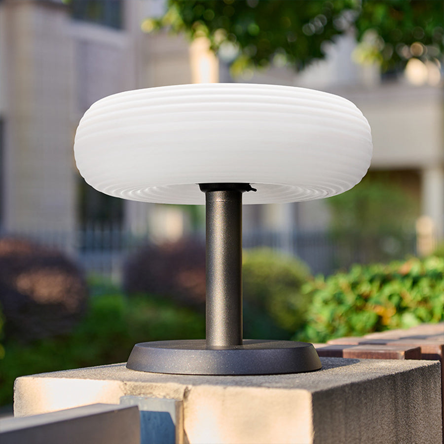 Elegant mushroom light creating ambient illumination on outdoor patio with modern furniture