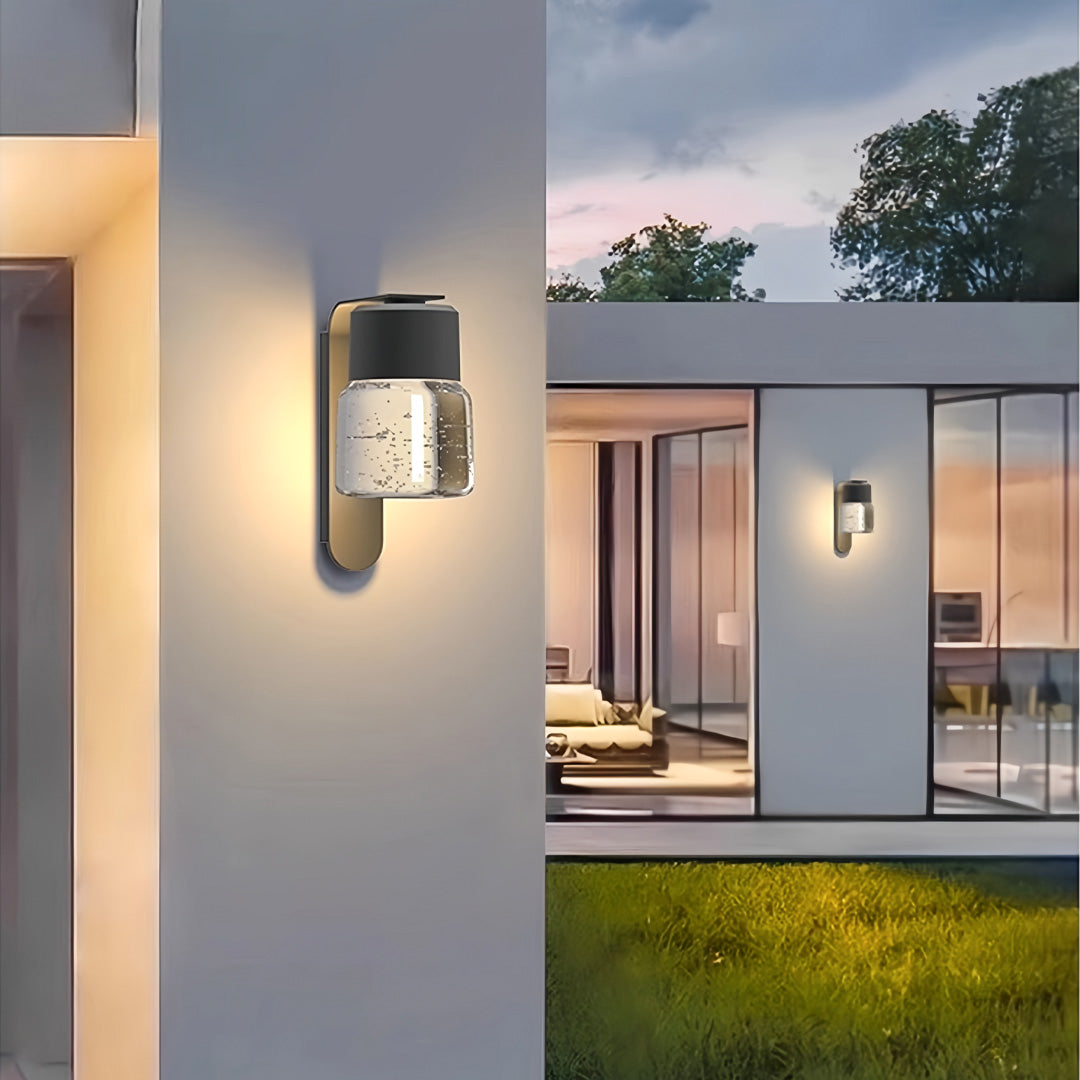 Contemporary exterior wall mount lights illuminating a modern patio area at dusk.