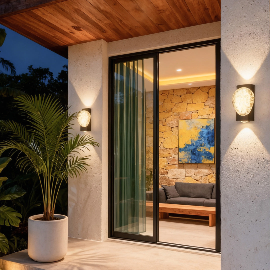 Contemporary gold up and down outdoor wall lights mounted near large glass doors, enhancing the outdoor patio space.