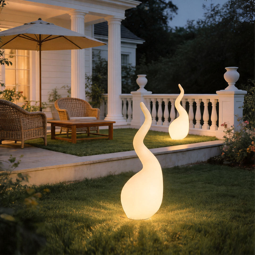 Patio outdoor floor lamps illuminating modern garden patio with soft decorative glowing effect.