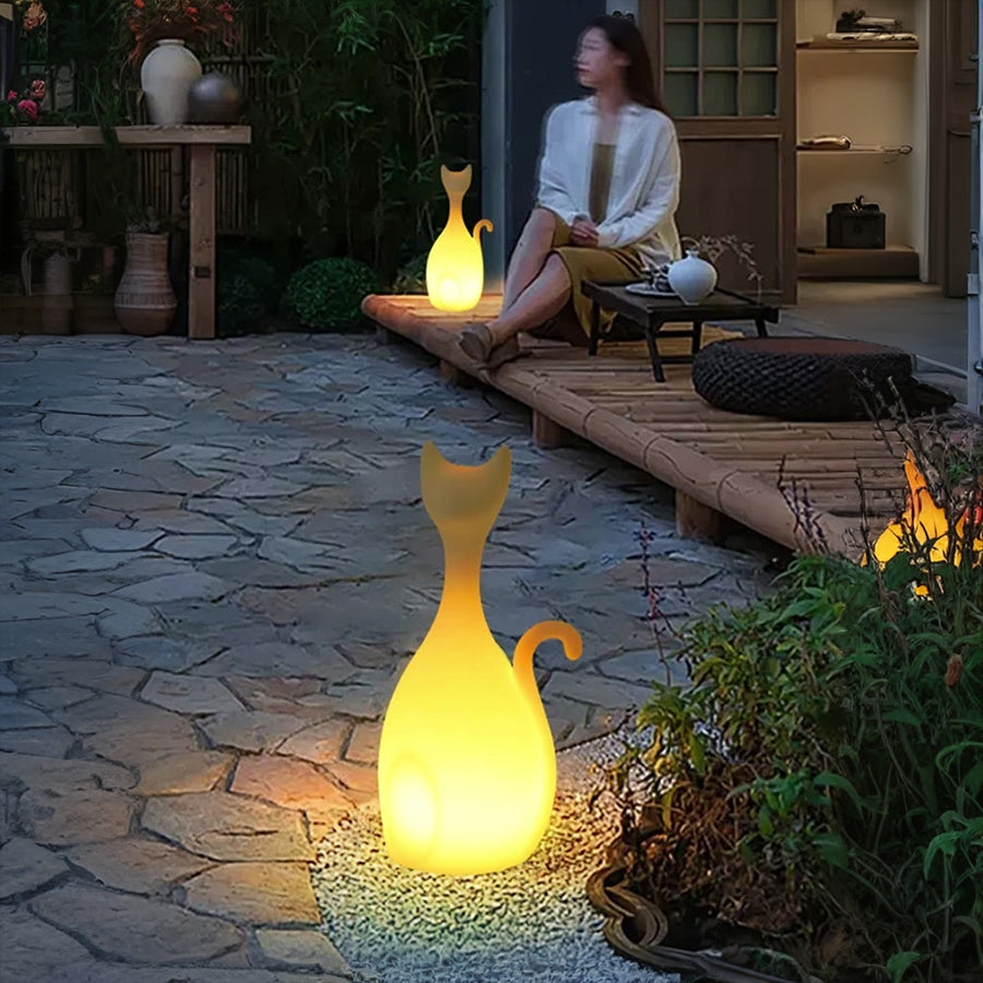 Person relaxing on patio with illuminated cat-shaped decorative lights creating cozy evening atmosphere
