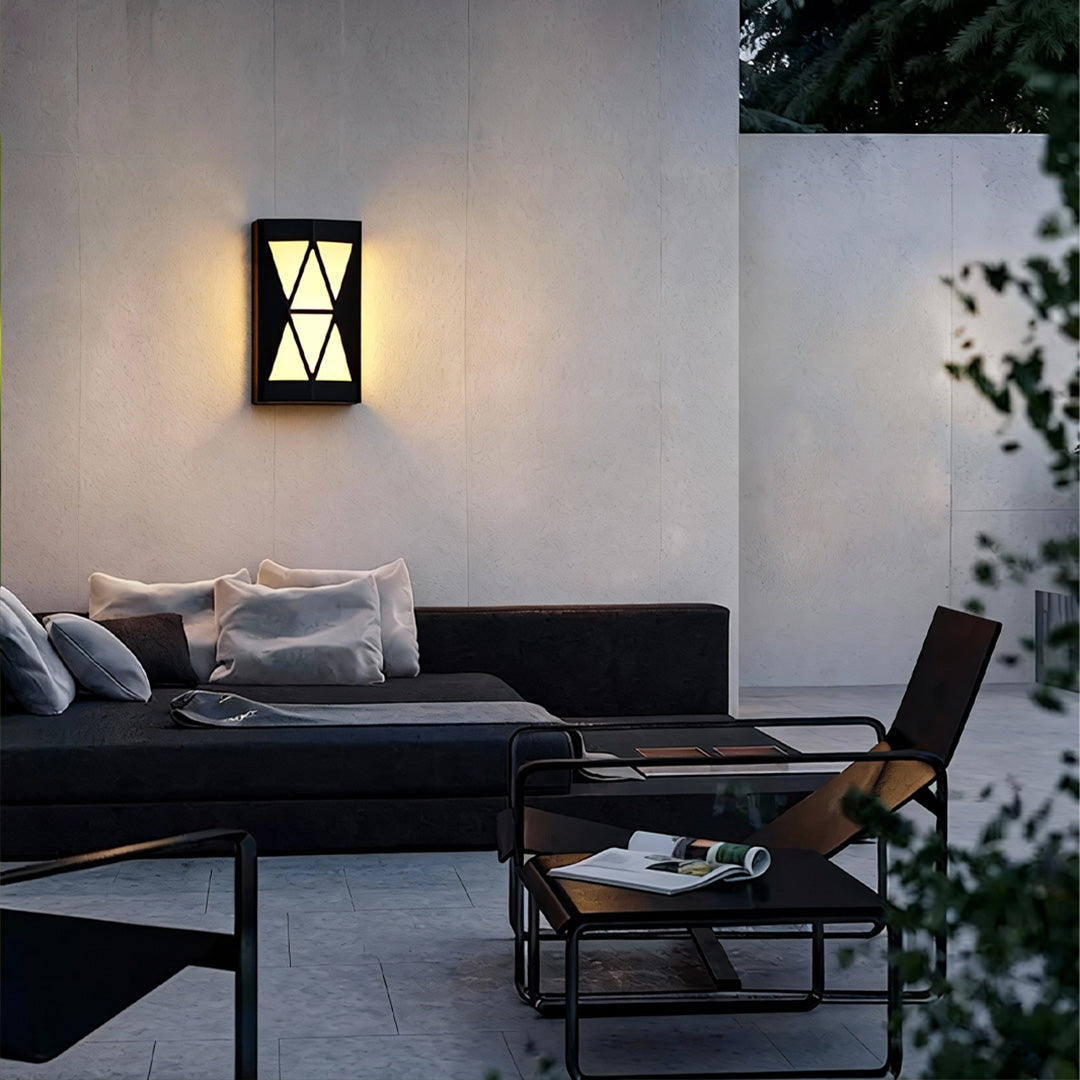 Outdoor wall sconces lighting illuminating a modern patio area with cozy seating and decorative plants.